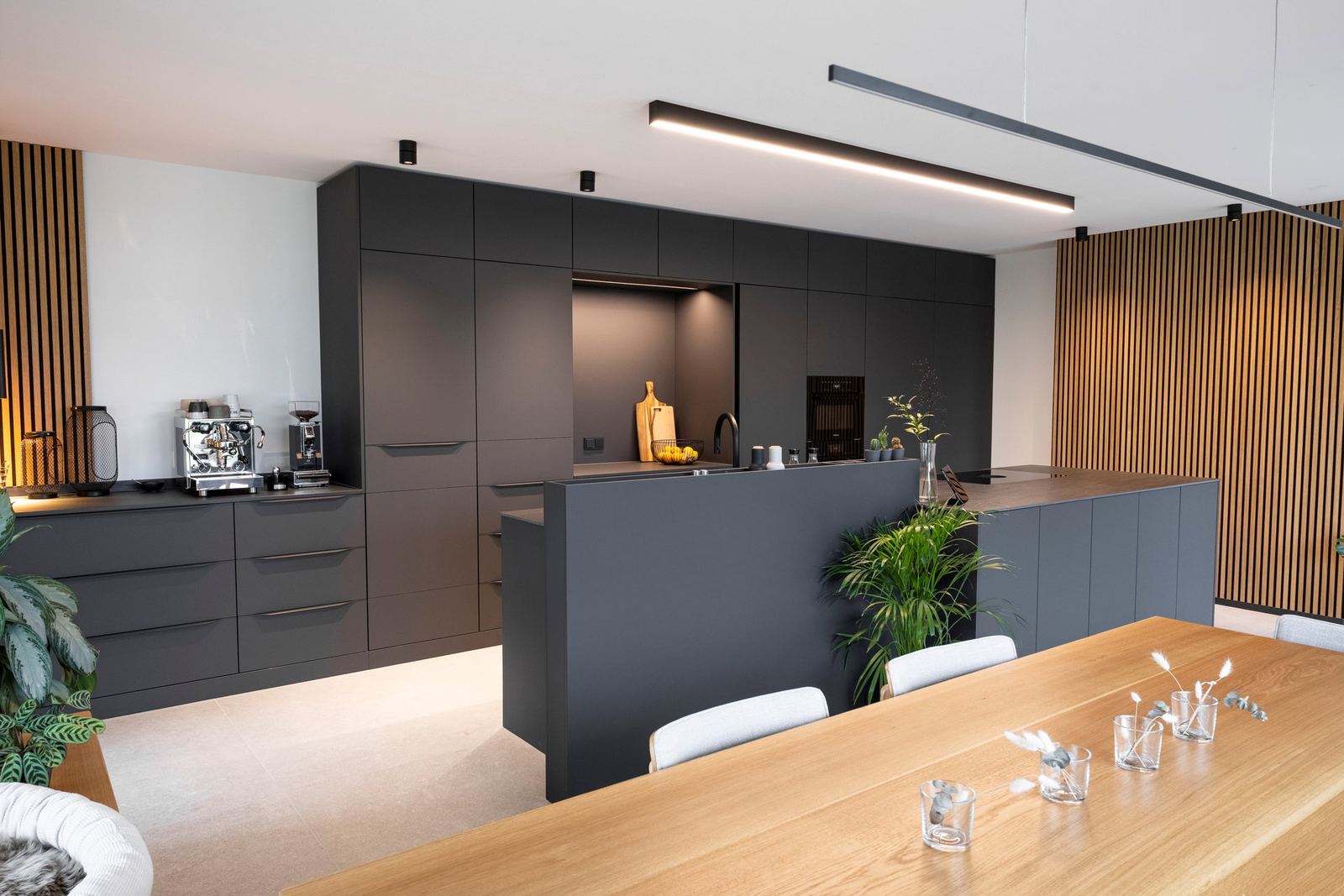 Küche in Carbongrau mit Kaffeebar, Brüstung am Mittelblock und Esstisch aus Eiche
